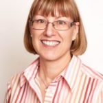 A woman wearing glasses and a striped shirt.