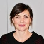 A woman in a black sweater posing for a photo.