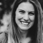 A black and white photo of a woman smiling.