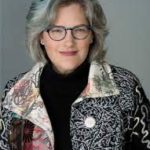 A woman wearing glasses and a colorful jacket.