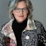 A woman wearing glasses and a colorful jacket.