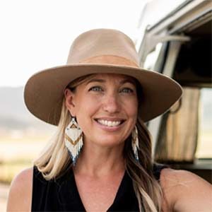 A woman wearing a hat and earrings.