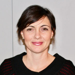 A woman wearing a black sweater and red lipstick.