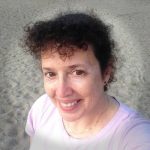 A woman taking a selfie on the beach.