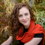 A copywriter woman with curly hair and a red scarf.