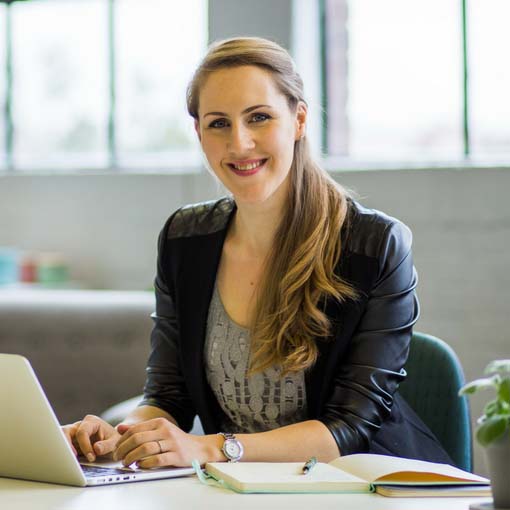 A woman sitting at a desk with a laptop.