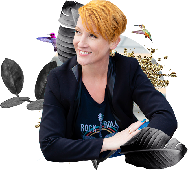 A woman with red hair sitting in front of a bunch of leaves.