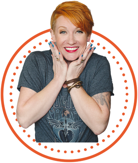 A woman with orange hair posing with her hands on her hips.