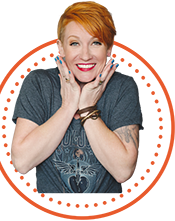 A woman with red hair posing with her hands on her hips.