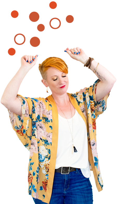 A woman in jeans and a floral kimono is posing for a photo.