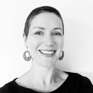 A black and white photo of a woman smiling.