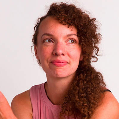 A woman with curly hair holding a frisbee.