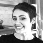 A black and white photo of a woman smiling.