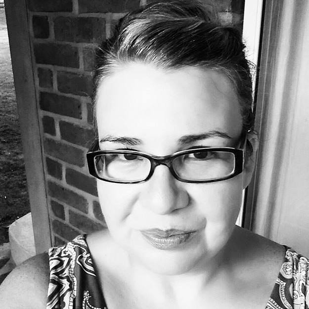 A black and white photo of a woman wearing glasses.