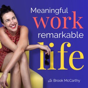 A woman in a red dress sits smiling on a yellow chair. Text reads, "Meaningful work, remarkable life with Brook McCarthy.