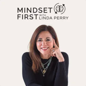 A woman in a black sweater, wearing layered necklaces, smiles and rests her face on her hand. Above her are the words "Mindset First with Linda Perry" and a brain graphic with arrows.